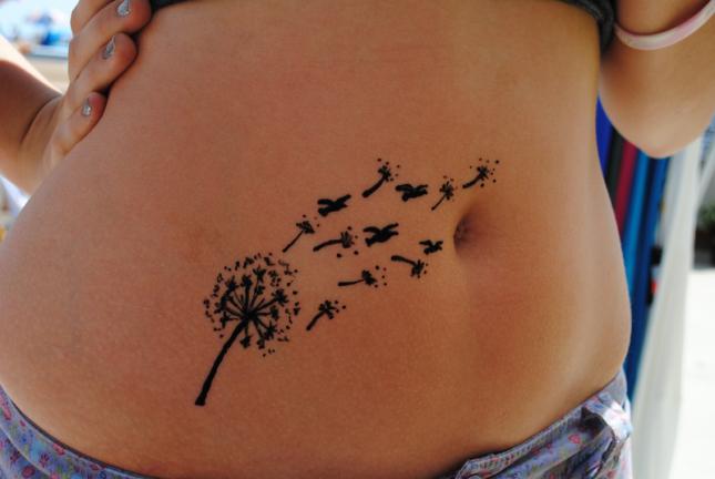 tatuagem feminina na barriga de dente de leão