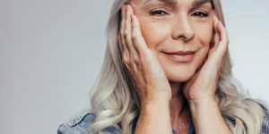 mulher madura segurando o rosto entre as mãos